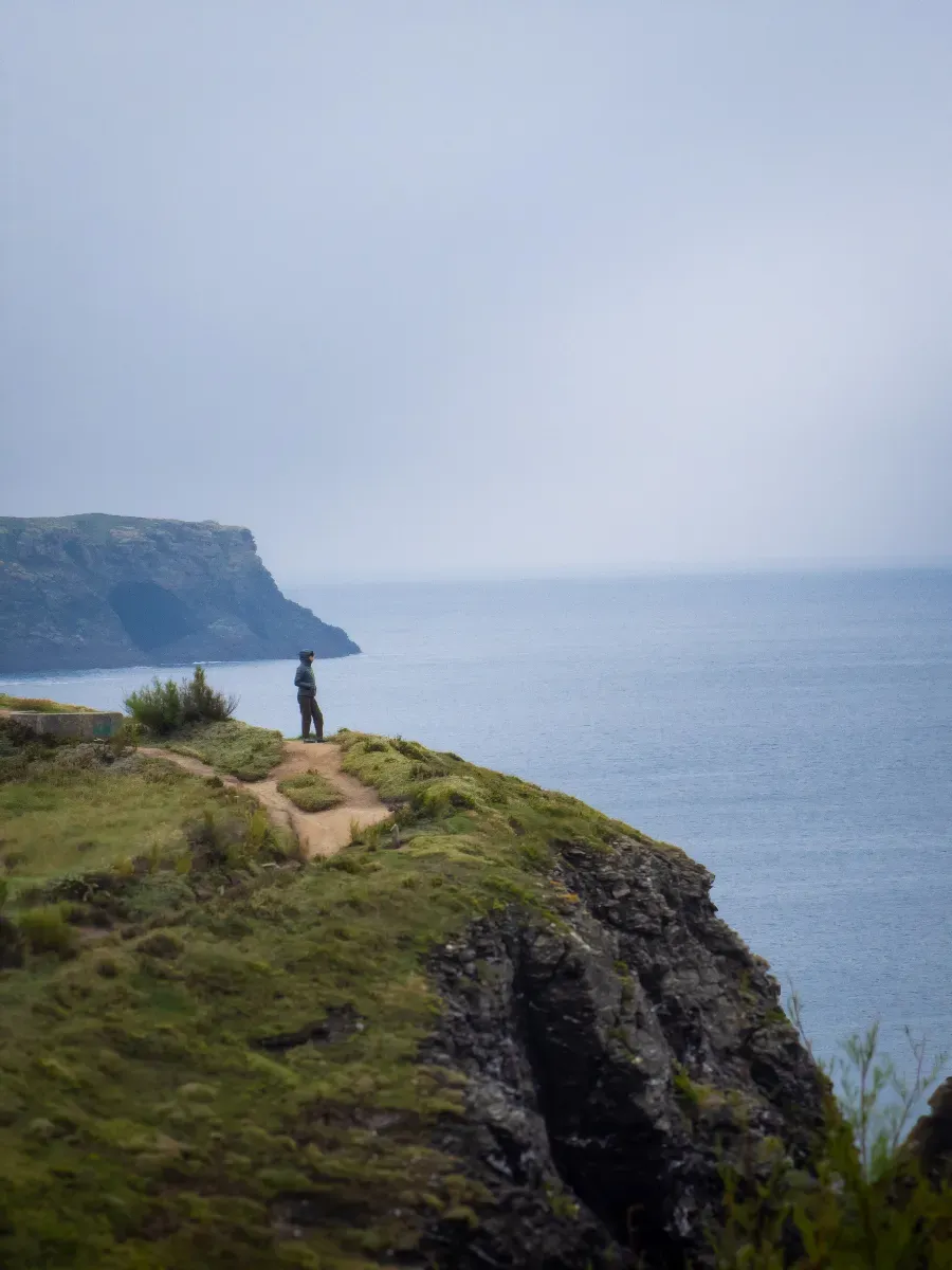 Personne debout au bord d’une falaise face à l’océan - Format portrait