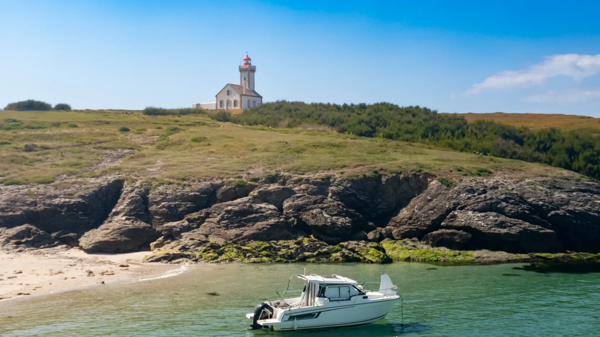 Petit bateau au mouillage à la plage des Poulains, sous le phare à Belle-Île-en-Mer.
