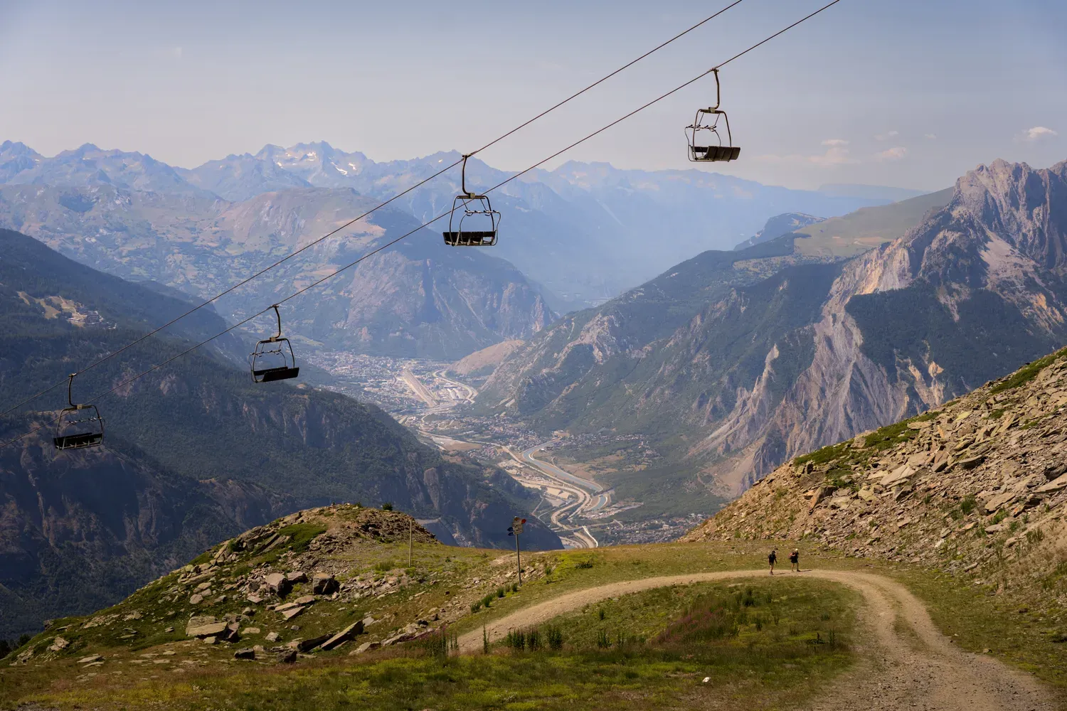 Photographie de télécabines au-dessus de la vallée.