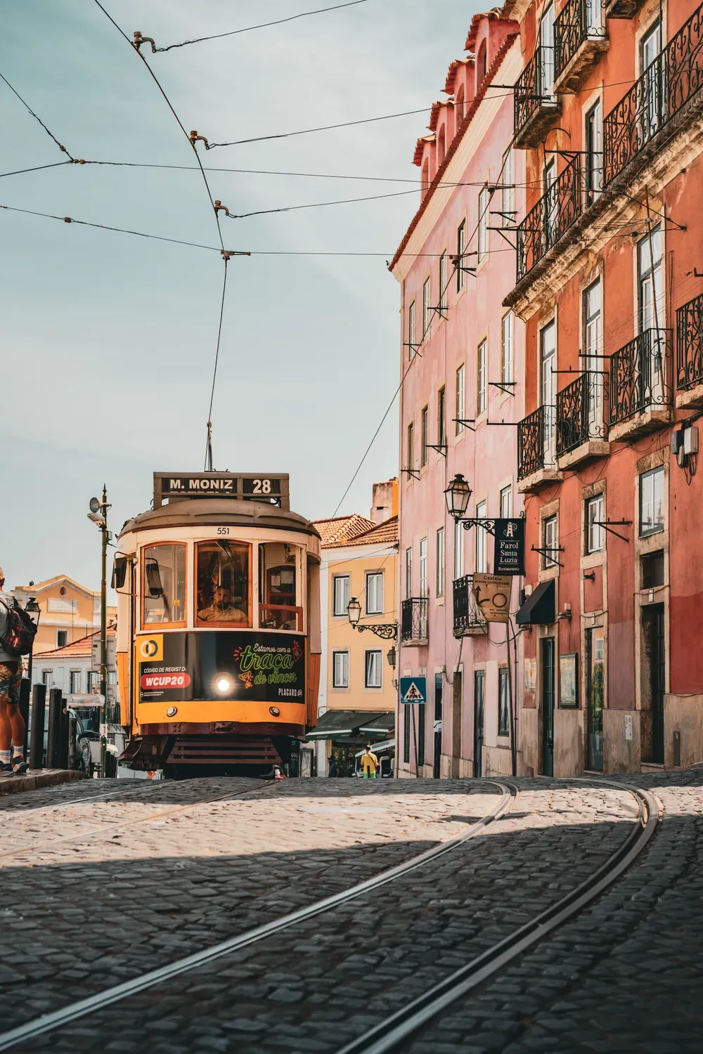 Photographie d un tramway jaune dans une rue pavee de Lisbonne.