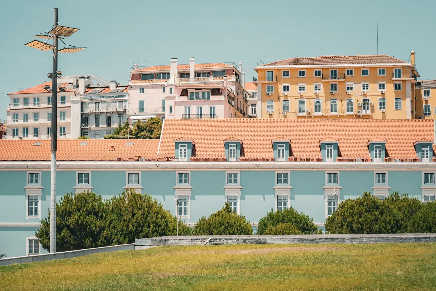 Photographie de facades pastel et d un jardin dans un quartier de Lisbonne.