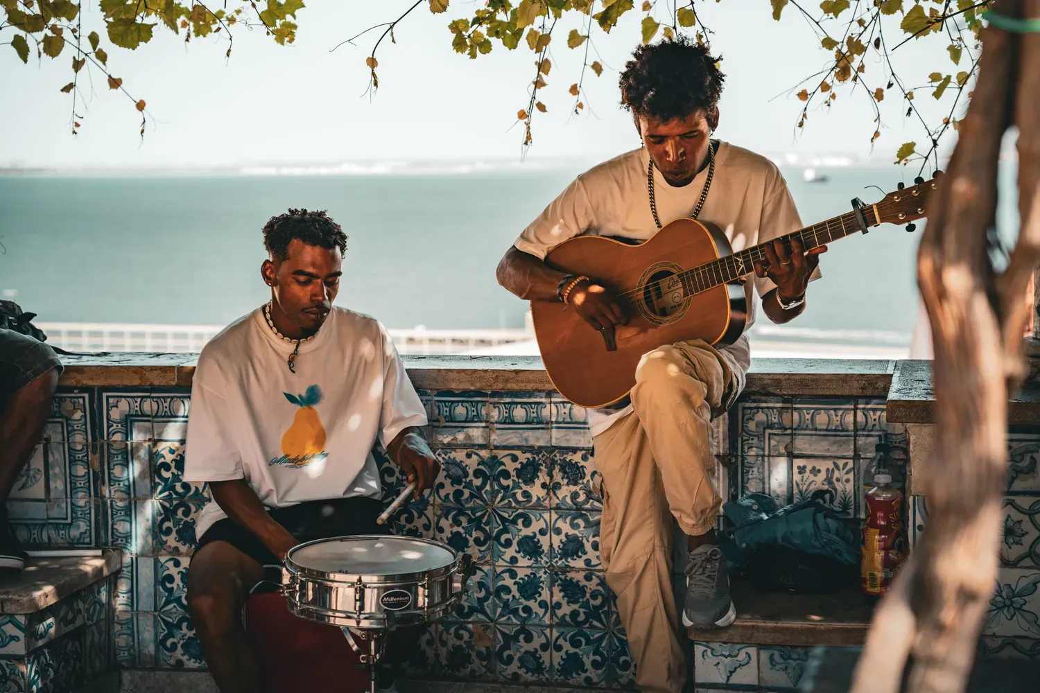 Photographie de deux musiciens jouant au belvedere devant des azulejos.