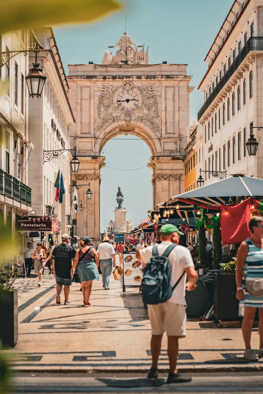 Photographie de passants sous l arc de la Rua Augusta a Lisbonne.