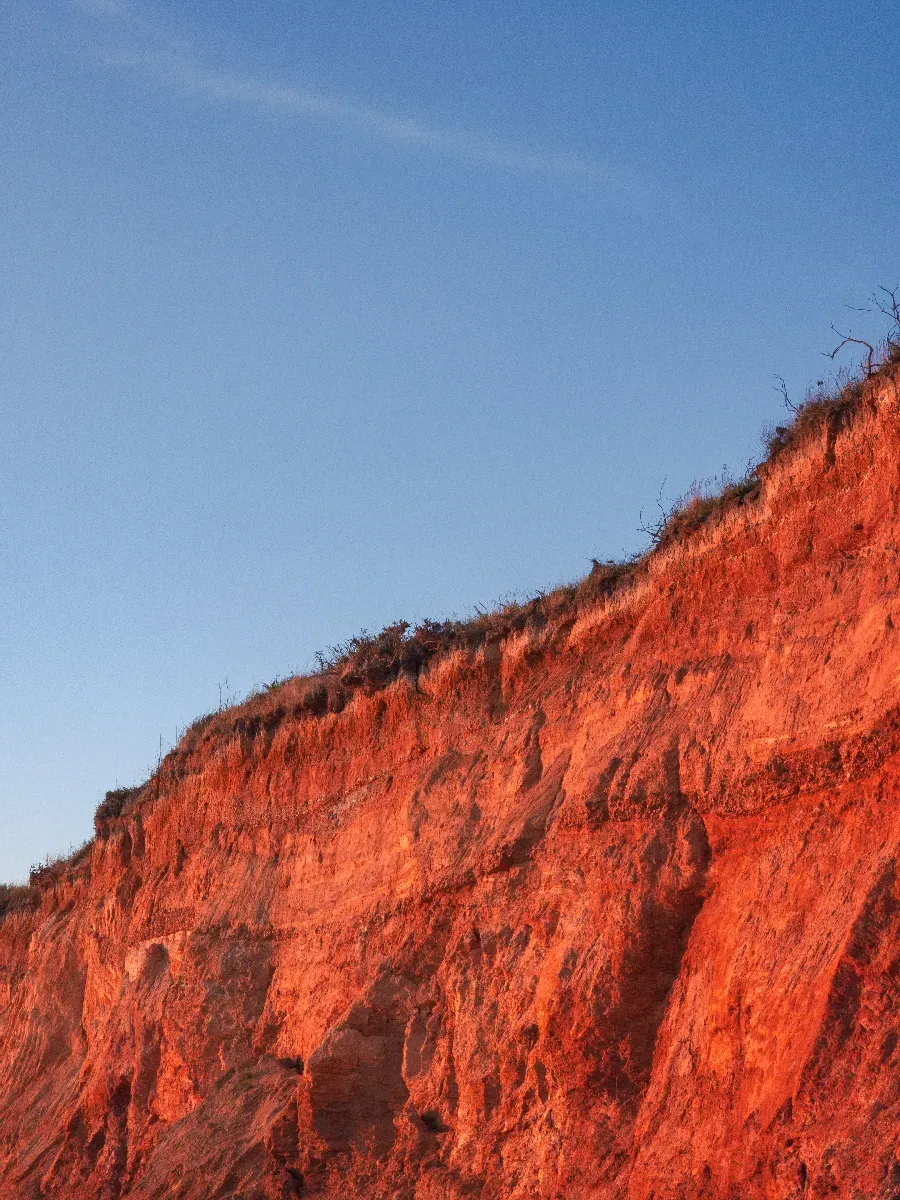 Falaise de la Mine d’Or éclairée par la lumière orangée du coucher de soleil.