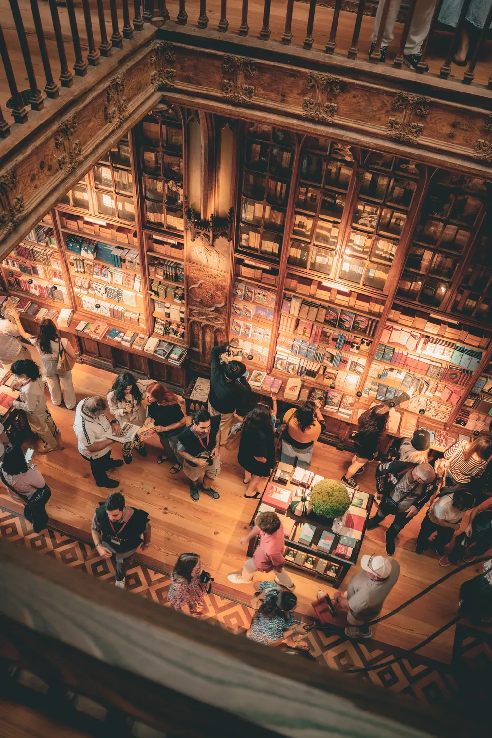 Photographie en hauteur d une librairie ancienne remplie de visiteurs a Porto.