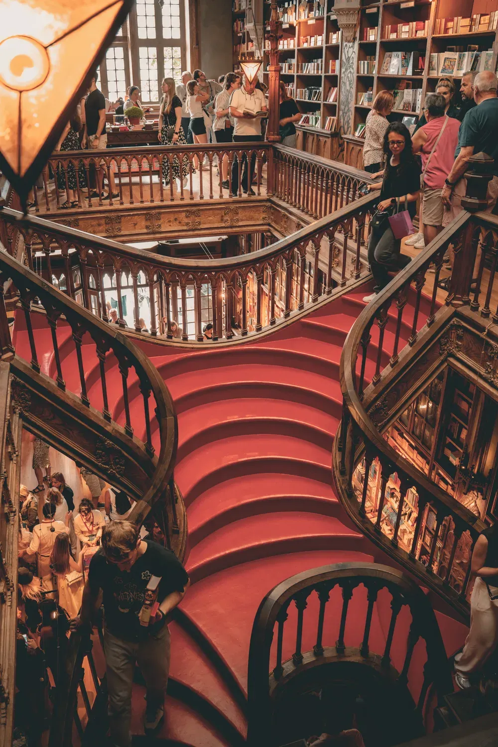 Photographie de l escalier rouge central d une librairie ancienne a Porto.