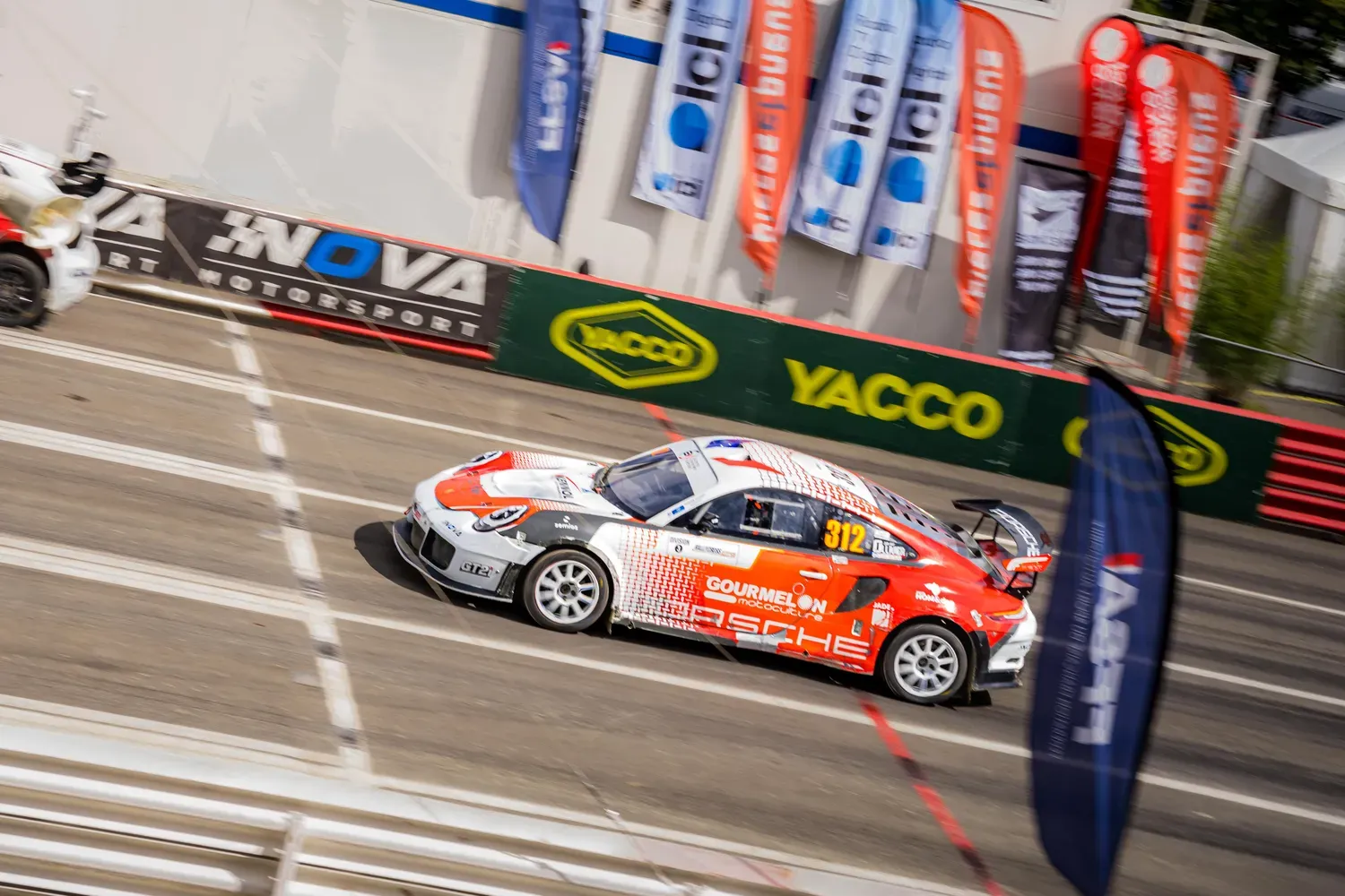 Photographie de voiture orange en virage.