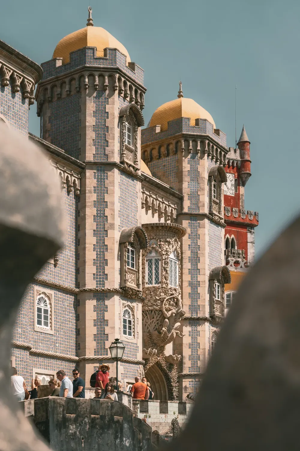 Photographie du palais de Pena encadre par un element en pierre au premier plan.