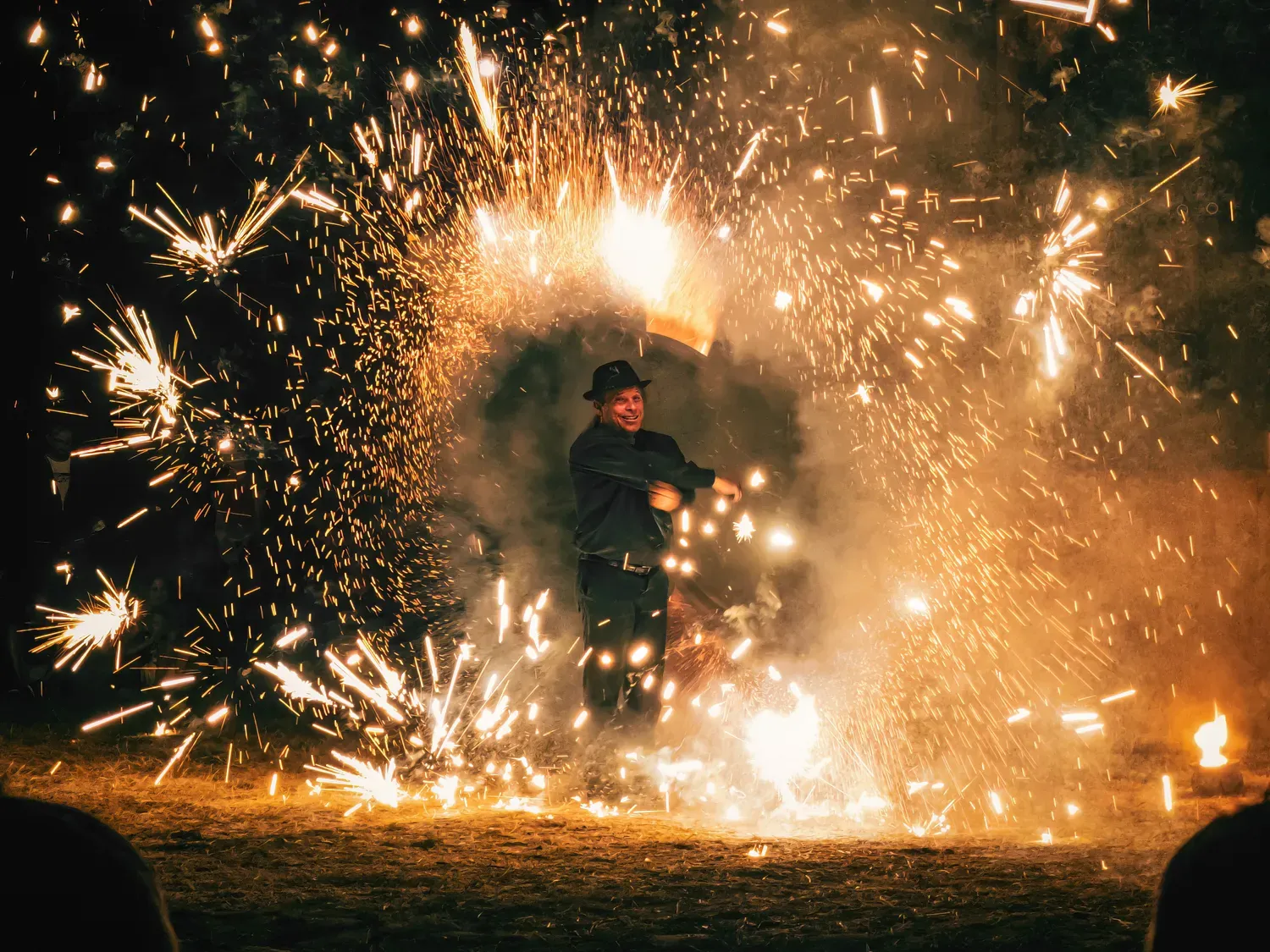 Photographie de cracheur de feu sous les étincelles.